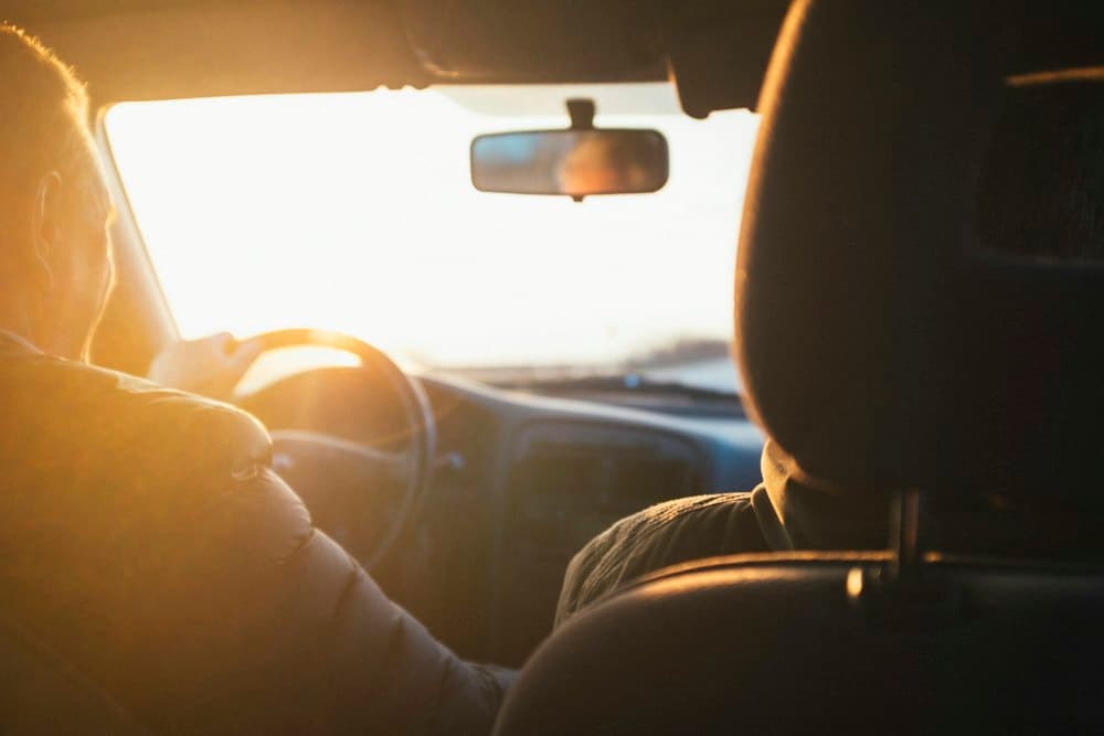 Man driving a car at golden hour