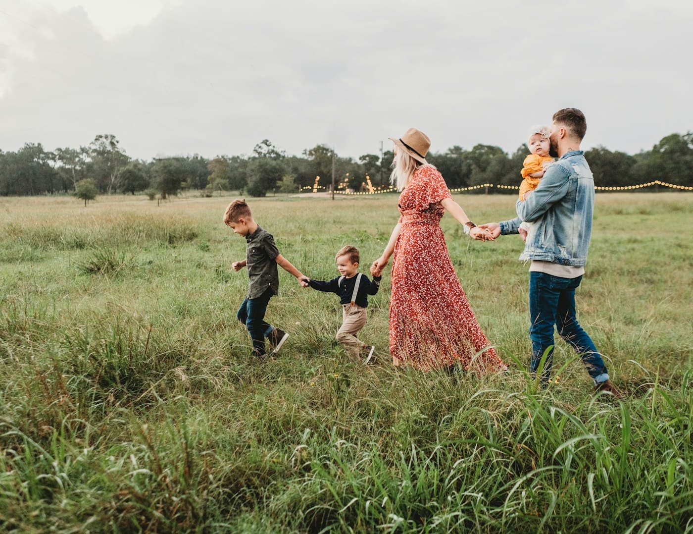 Parents holding hands with their toddler on a walk